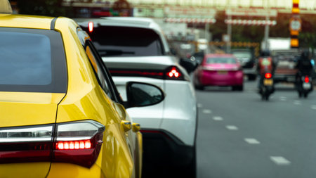Rear side of luxury yellow car with turn on brake light. Cars queued up and braked in the congested lane. Other lanes had clear traffic.の写真素材