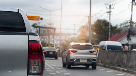 Close up rear side of pickup car silver color. Car is driving in the left lane. And on the right lane there is another car driving with its brake lights on.の写真素材