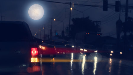 Blurred of taillight of pickup car at night. Car stop and turn on right signal for turn right in the junction. Opposite road with many cars stop to allow cars.の写真素材