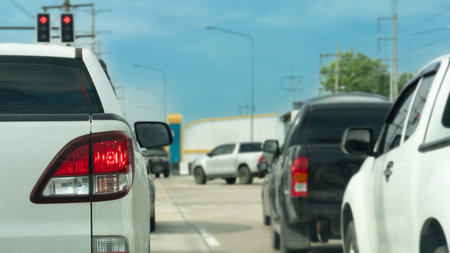 Rear side of pickup white car stop or parking on the road. Turn on brake light in the junction from traffic red light control with other cars. Car on the right drives through firstの写真素材