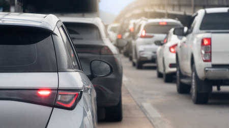Rear side of grey car driving on the concrete road. Traffic congestion. Cars queue and long line ahead. Different level bridge on the side.の写真素材