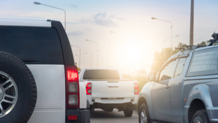Rear side family car white color SUV model. Many cars driving on the road with sunlight on the sky.の写真素材