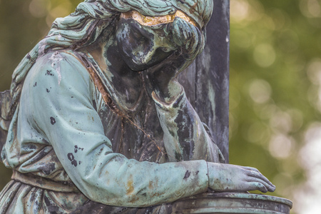 Sculpture of a female angel made from metal stands in grnem Park.の写真素材