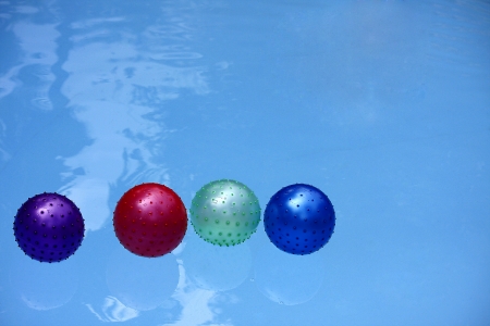 Four Color Balloon Floating in Swimming Pool  の写真素材