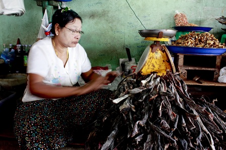 Lifestyle of Myanmar People. Old style Market or Grocery sell food, meat, fish, vegetable,canned food,tobacco leaf, garment, gold, gem, electronic, computer, mobile and etc. People still wear sarong and worship Buddhism,woman make up with Tanaka or Thanakのeditorial素材