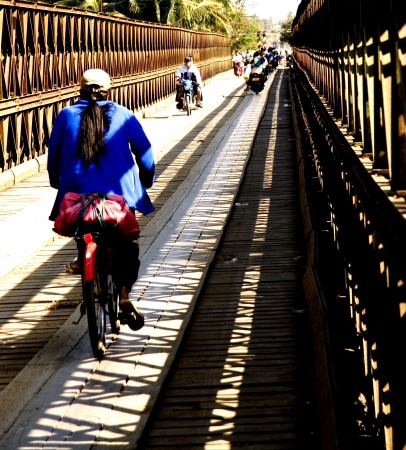 Laos Girl drive bicycle croos Loas Bridge at Louangphabang  のeditorial素材