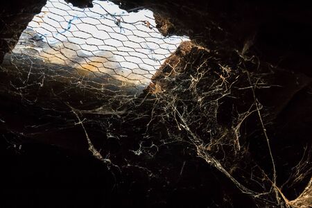 Old Cobwebs in abandoned house, The spider net under the roof with sun through, Close Up shot.の写真素材