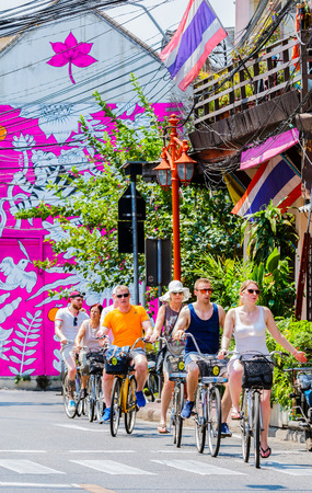 BANGKOK, THAILAND - MARCH 13, 2016 : Tourist group ride the bicycle around ancient chinatown. Background is Graffiti on the building. Once should not be missed in Bangkok.のeditorial素材