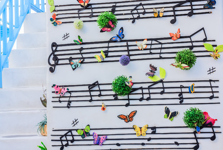 The notation scale and butterfly model are decoration on the white wall.の写真素材