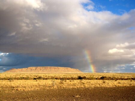 Namibian landscape with rainbow over yellow savannahの写真素材