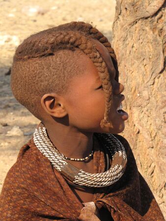 NAMIBIA, KAOKOVELD, AUGUST 29: Himba girl presenting her braids in the village of Himba people near Opuwo in northern Namibia, August 29, 2009, Namibiaのeditorial素材