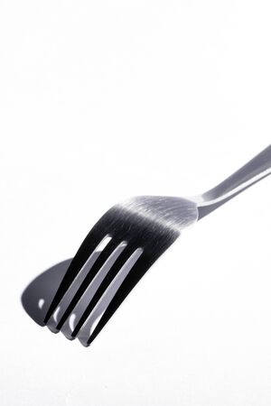 Top Os A Stainless Steel Fork With Shadow On A White Backgroundの写真素材