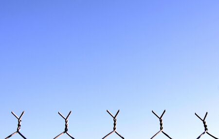 Top Of A Metal Security Fence In Front Of A Clear Blue Sky, Backgroundの写真素材