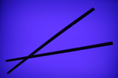 Silhouette Of A Pair Of Chopsticks On A Blue Backgroundの写真素材
