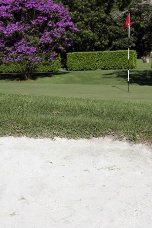 Golf Putting Green With Flag And Sand Bunker In The Foreground の写真素材
