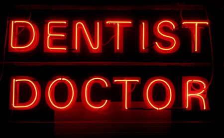 Dentist Doctor - Red Neon Light Advertising On A Black Backgroundの写真素材