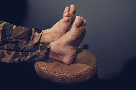 Barefoot man feet on stoolの写真素材