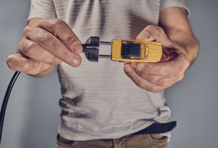 Man with toy car and electricity plugの写真素材