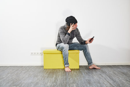 Man using his smartphone on a green boxの写真素材