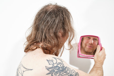 Man looking into mirror in handの写真素材