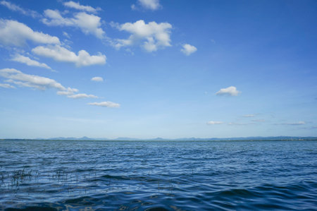 Big clouds rising up over the calm water.の写真素材