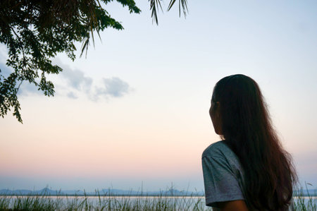 Relaxing female sitting at the lake with morning light.の写真素材