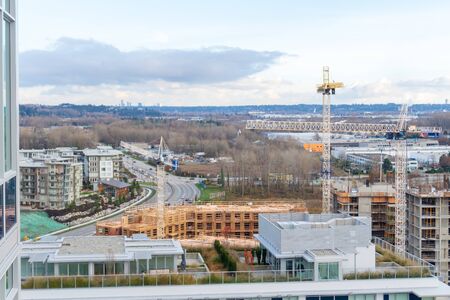 Aerial top view of the River District - apartment housing developments under construction in Vancouver, BC, on Marine Drive. Cranes in scene. Concrete and wood-frame buildings.のeditorial素材