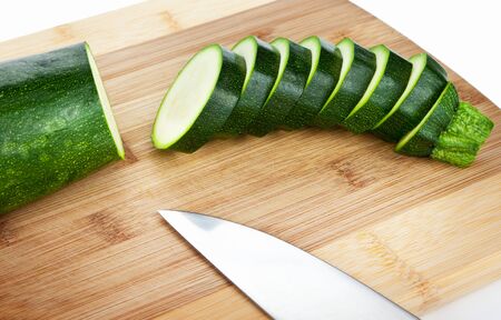 Sliced zucchini on a wooden cutting boardの写真素材