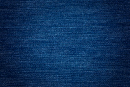 Dark blue denim background, detailed texture with vignette