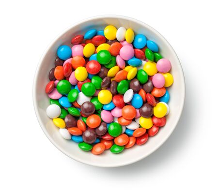 Colorful chocolate candy pills in bowl isolated on white background. Top viewの写真素材