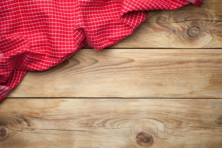 Red tablecloth on wooden background. Top view. Copy spaceの写真素材