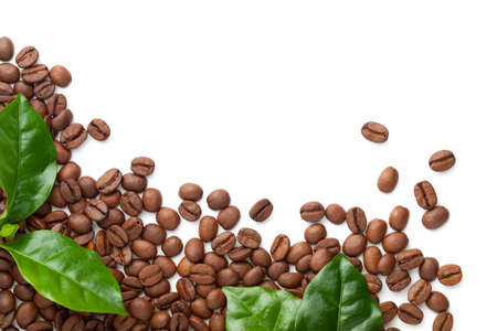 Spilled coffee beans with green leaves isolated on white background. Roasted arabica. Copy space. Top viewの写真素材