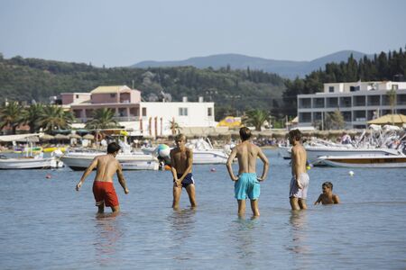 CORFU, GREECE - AUGUST 19, 2016: Young people at Sidari beach playing with ball in waterのeditorial素材