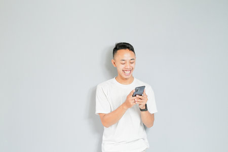 a young Asian man is smiling while on a video callの写真素材