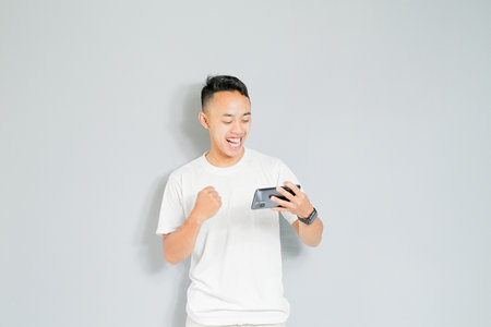 a young Asian is happy when he wins the gameの写真素材