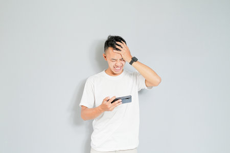 a young Asian is stressed because he lost a gameの写真素材