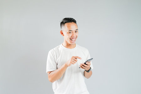 a young Asian man is showing something on a smartphoneの写真素材