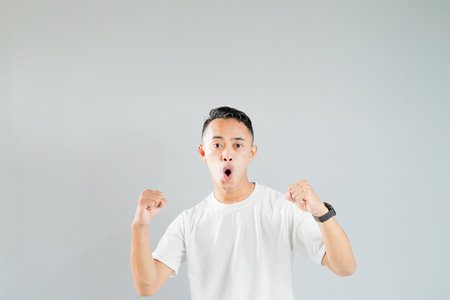 a young asian man with a passionate expression, isolated on a gray backgroundの写真素材