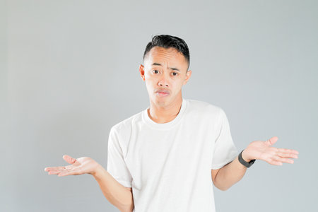 a young asian is showing an expression of not knowingの写真素材