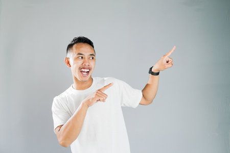 a young asian is pointing towards somethingの写真素材