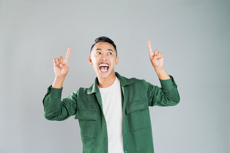 a young asian is pointing towards somethingの写真素材