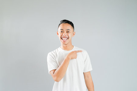 a young asian is pointing towards somethingの写真素材