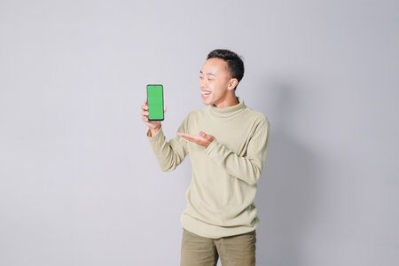 a young Asian man is showing something on a smartphoneの写真素材