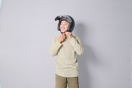 young asian man wearing helmet, isolated on gray backgroundの写真素材
