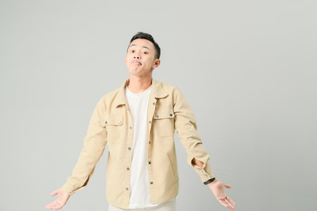 a young asian is showing an expression of not knowingの写真素材