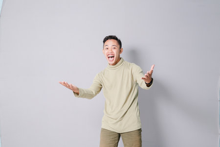 Asian youth is having euphoria, isolated on gray backgroundの写真素材