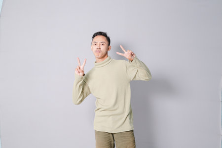 Asian youth is having euphoria, isolated on gray backgroundの写真素材