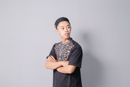 young asian muslim folding hands, gray backgroundの写真素材