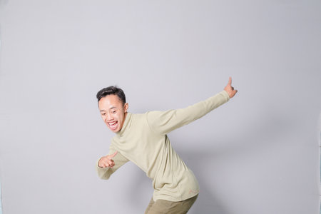 Asian youth is having euphoria, isolated on gray backgroundの写真素材