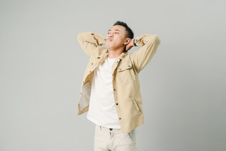 young asian man with disappointed expression, isolated on gray backgroundの写真素材